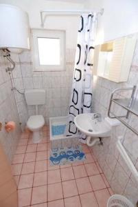 a bathroom with a toilet and a sink at Apartments Kraj, Tratica Beach in Kraj