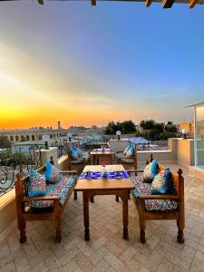 un patio con 2 tavoli e sedie su un balcone di Bobosh Boutique a Bukhara Altre 88 foto