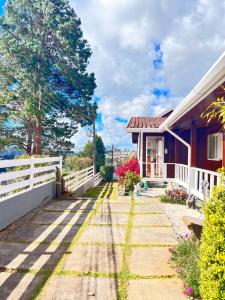 a house with a white fence and a yard at Pousada do Vento in Campos do Jordão