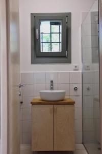 a bathroom with a sink and a mirror at Admonis - Home in the olive grove in Melissátika