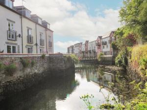 a river in a city with houses and buildings at 'Riverside' Summercourt in Penryn