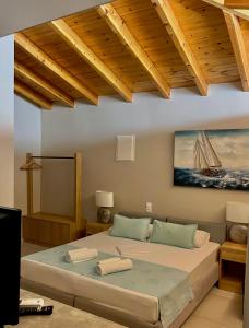 a bedroom with a bed with a painting on the wall at Oro in Skiathos