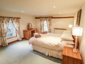 a bedroom with a large bed and two windows at Old Hall Farm in Spilsby