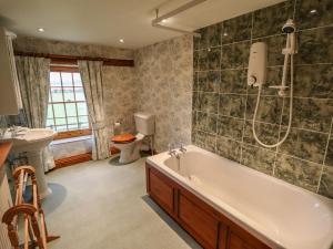 a bathroom with a tub and a toilet and a sink at Old Hall Farm in Spilsby