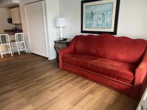 a red couch sitting in a living room at Seralago Hotel & Suites Main Gate East in Orlando