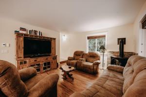 a living room with couches and a flat screen tv at 22MBR - Wi-Fi - Fireplace - Pets OK - Sleeps 8 cabin in Glacier