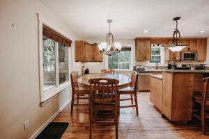 a kitchen with wooden cabinets and a table and chairs at 22MBR - Wi-Fi - Fireplace - Pets OK - Sleeps 8 cabin in Glacier