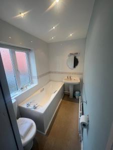 a white bathroom with a tub and a sink at The Bayridge Guest House in Bridlington +32 photos