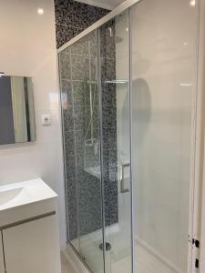 La salle de bains est pourvue d'une douche avec une porte en verre. dans l'établissement Squash Club Apartamentos, à Portimão