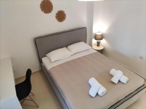 a bedroom with a bed with two pillows and a chair at Galini Rooms & Apartments in Finikas