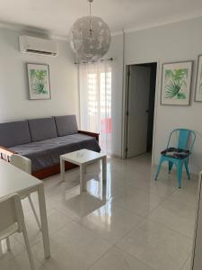 uma sala de estar com um sofá e uma mesa em Squash Club Apartamentos em Portimão