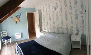 a bedroom with a bed and a blue wall at 2 Bed Cottage Sleeps 4 with Pool and Pet Friendly in Plémet