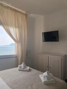 1 dormitorio con 2 toallas en una cama con ventana en Cielomare Residence Diffuso, en Trapani