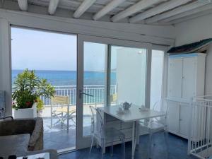 a living room with a table and a balcony with the ocean at Cielomare Residence Diffuso in Trapani