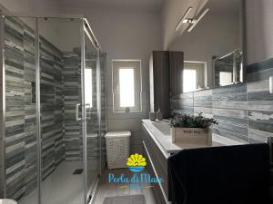 ein Bad mit einer Glasdusche und einem Waschbecken in der Unterkunft Perla di Mare in Siculiana