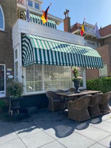 un patio con mesa, sillas y banderas en 't Molentje, en Zandvoort