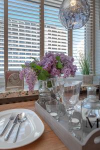 ヴェスターラントにあるAd5 409 Monis Beachhouseの皿と紫の花と眼鏡をかけたテーブル