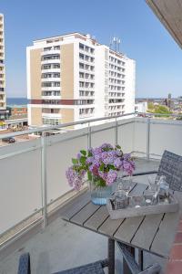 - une table avec un vase de fleurs sur le balcon dans l'établissement Ad5 409 Monis Beachhouse, à Westerland