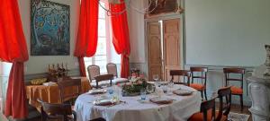 Château de Mauvilly في Mauvilly: غرفة طعام مع طاولة وستائر حمراء