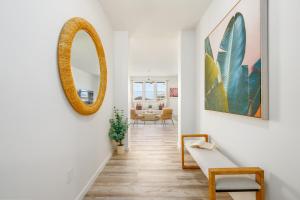 a hallway with a mirror and a chair at @ Marbella Lane - 3BR w/ Phenomenal Ocean+MT views in Waianae