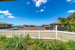 a white fence in front of some houses at @ Marbella Lane - 3BR w/ Phenomenal Ocean+MT views in Waianae