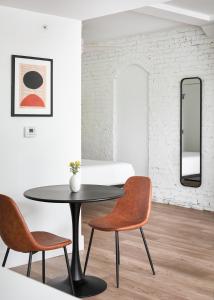 1 mesa y 2 sillas en una habitación con espejo en Kasa Studio Revival Atlanta, en Atlanta