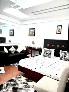 a bedroom with a bed and a couch at RB studio apartment with free Wi-Fi in Dar es Salaam