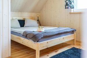 łóżko w pokoju z drewnianą ramą w obiekcie Chabrowa Oaza w Sasinie