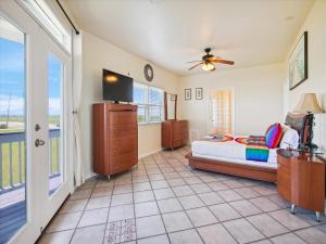 a bedroom with a bed and a tv and a window at Oceanside Paradise in Galveston