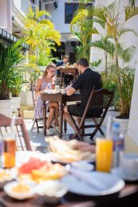 eine Gruppe von Menschen, die an einem Tisch in einem Restaurant sitzen in der Unterkunft New Old Dutch House - Galle Fort in Galle