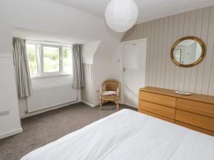 une chambre avec un lit, une commode et un miroir dans l'établissement Ashdown House, à Saundersfoot