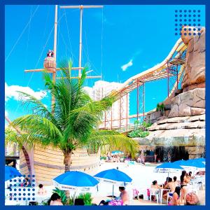 eine Gruppe von Menschen, die in einem Themenpark unter Sonnenschirmen sitzen in der Unterkunft Com CAFE SPAZZIO DIROMA e ACESSO ao ACQUA Parque DIROMA TODOS OS DIAS in Caldas Novas