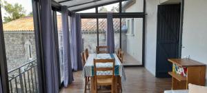 une salle à manger avec une table et un balcon dans l'établissement La Grangette du Mas, à Chassiers