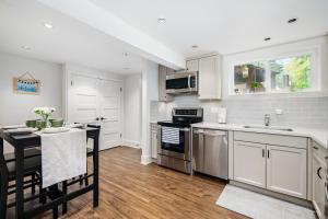a kitchen with stainless steel appliances and a table at Gorgeous 4-Bedroom Garden Level Suite at Vancouver West in Vancouver