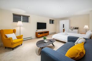 uma sala de estar com um sofá azul e uma cama em Gorgeous 4-Bedroom Garden Level Suite at Vancouver West em Vancouver