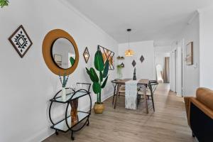 a living room with a table and a mirror at Boho Inspired Apt in the heart of Tampa Bay! in Tampa