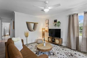 a living room with a couch and a tv at Boho Inspired Apt in the heart of Tampa Bay! in Tampa