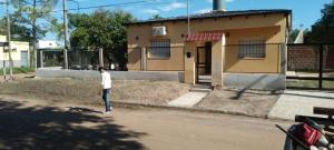 Un uomo che cammina per la strada di fronte a una casa di Casa Iberá a Mercedes