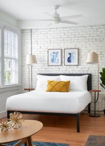 1 dormitorio con 1 cama con pared de ladrillo blanco en Kasa Studio Revival Atlanta en Atlanta
