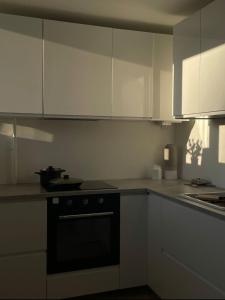a kitchen with white cabinets and a black oven at SEASIDE APARTMENT in Liepāja