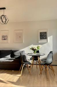 Una sala de estar con un sofá y una mesa con sillas. en SEASIDE APARTMENT, en Liepāja