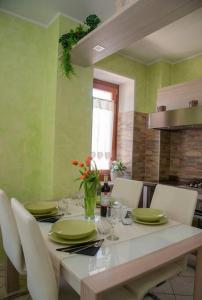 a dining room with a table with green walls at *[Stella Alpina]*accogliente casa, giardini, wi-fi in Borgo Lares