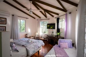 a bedroom with a bed and a desk and windows at Hotel Santo Cerro Natural Park in Santo Cerro