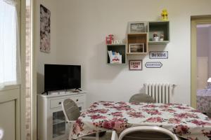 ein Esszimmer mit einem Tisch und einem TV in der Unterkunft Luma ospitalità in Molfetta