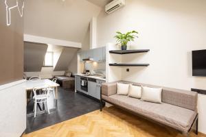 a living room with a couch and a kitchen at Sophie's Hostel in Prague