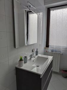 a white bathroom with a sink and a mirror at Casa Trezza 3 in Latina