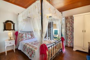 a bedroom with a canopy bed and a window at Evi's Maisonette in Longós