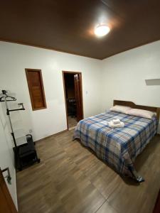 una camera con un letto con una coperta blu scozzese di Kitnet aconchegante próximo à Praia do Forte a Mata de Sao Joao
