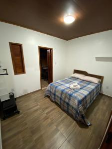 una camera con un letto con una coperta blu scozzese di Kitnet aconchegante próximo à Praia do Forte a Mata de Sao Joao