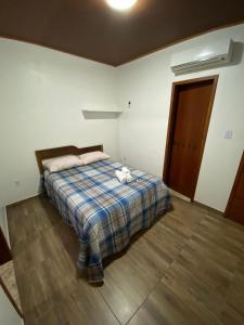 una camera da letto con un letto e un animale di peluche di Kitnet aconchegante próximo à Praia do Forte a Mata de Sao Joao